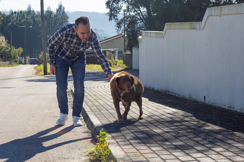 Leonel Costa passeia com o cão Bobi em 4 de fevereiro de 2023, em Conqueiros, em Leiria, Portugal, pouco antes do 31º aniversário do cachorro — Foto: REUTERS/Catarina Demony/Foto de arquivo