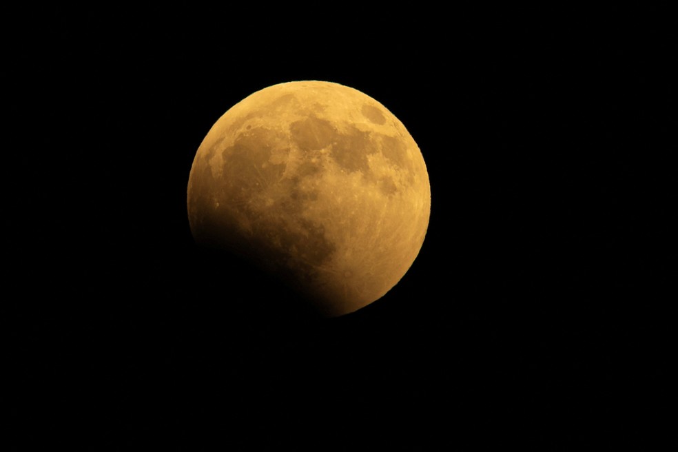 In�cio do eclipse lunar, com a Lua em tons avermelhados, � visto em San Diego, na Calif�rnia, nesta quinta-feira (27). � Foto: Mike Blake/Reuters