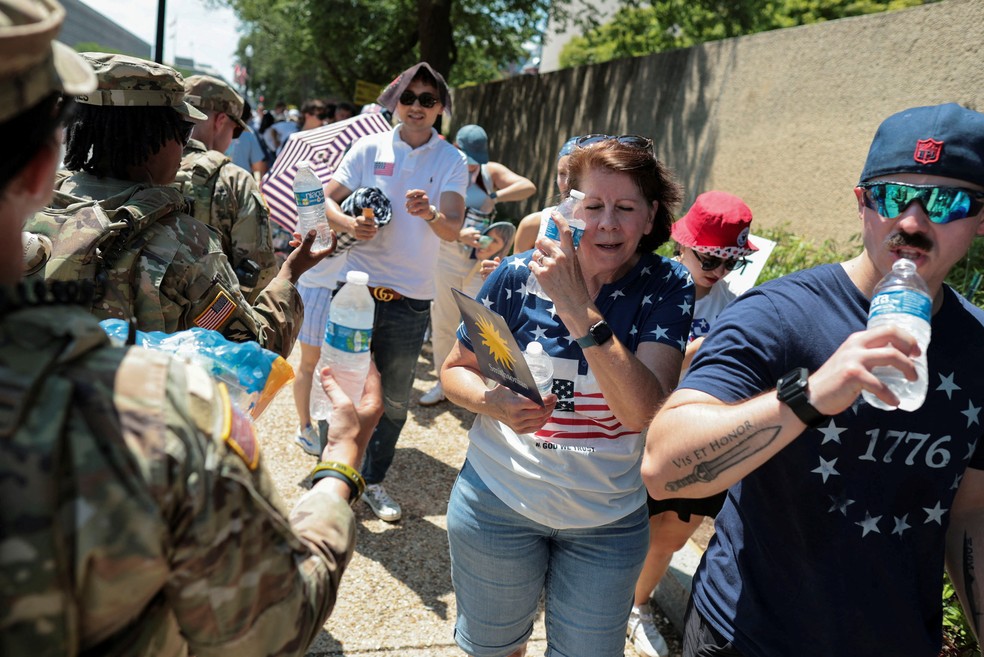 Soldados da Guarda Nacional distribuem garrafas d'água para visitantes do Great American State Fair no National Mall, em Washington D.C., nos Estados Unidos, em 4 de julho de 2026. — Foto: REUTERS/Jonathan Ernst