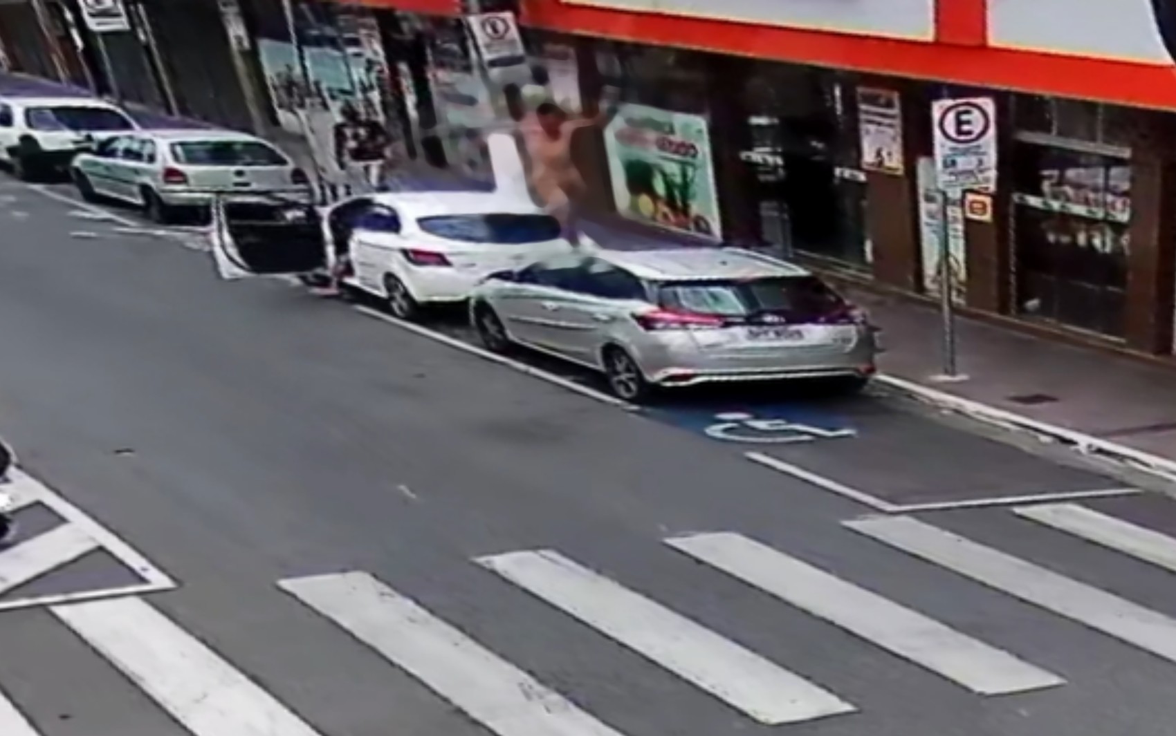 Câmera de segurança flagra homem pulando sobre carros no Centro de Pouso Alegre, MG