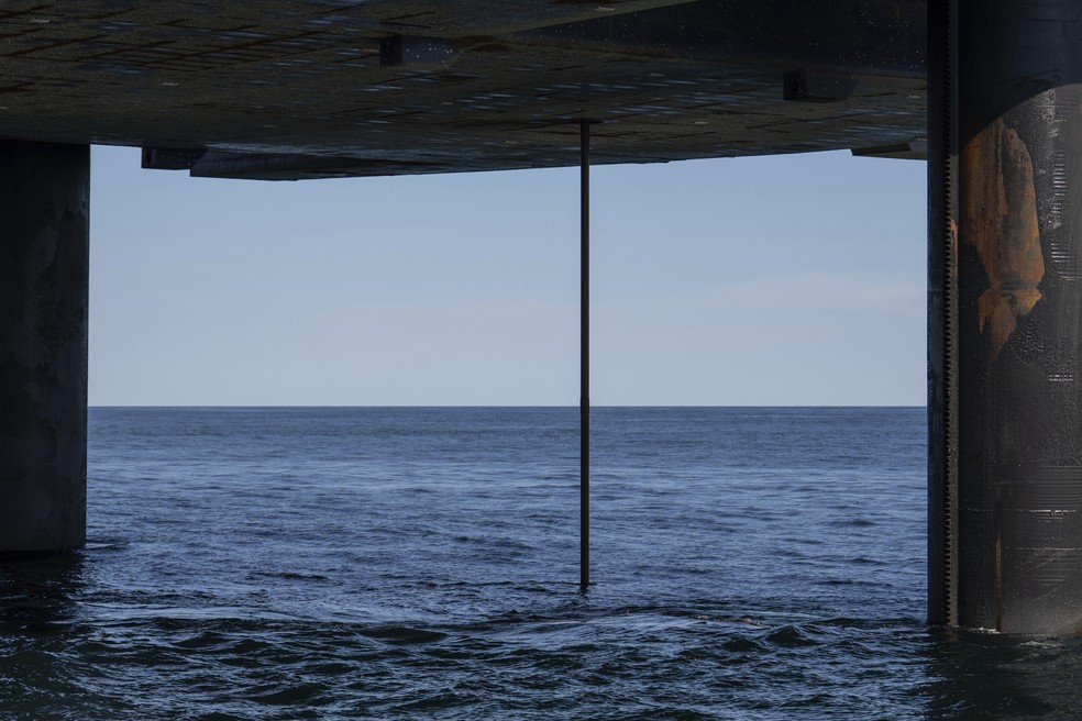Tubo de perfuração é visto sob a plataforma Liftboat Robert, a partir da embarcação de apoio Gaspee, no Atlântico Norte, em 19 de julho de 2025. — Foto: Carolyn Kaster/AP