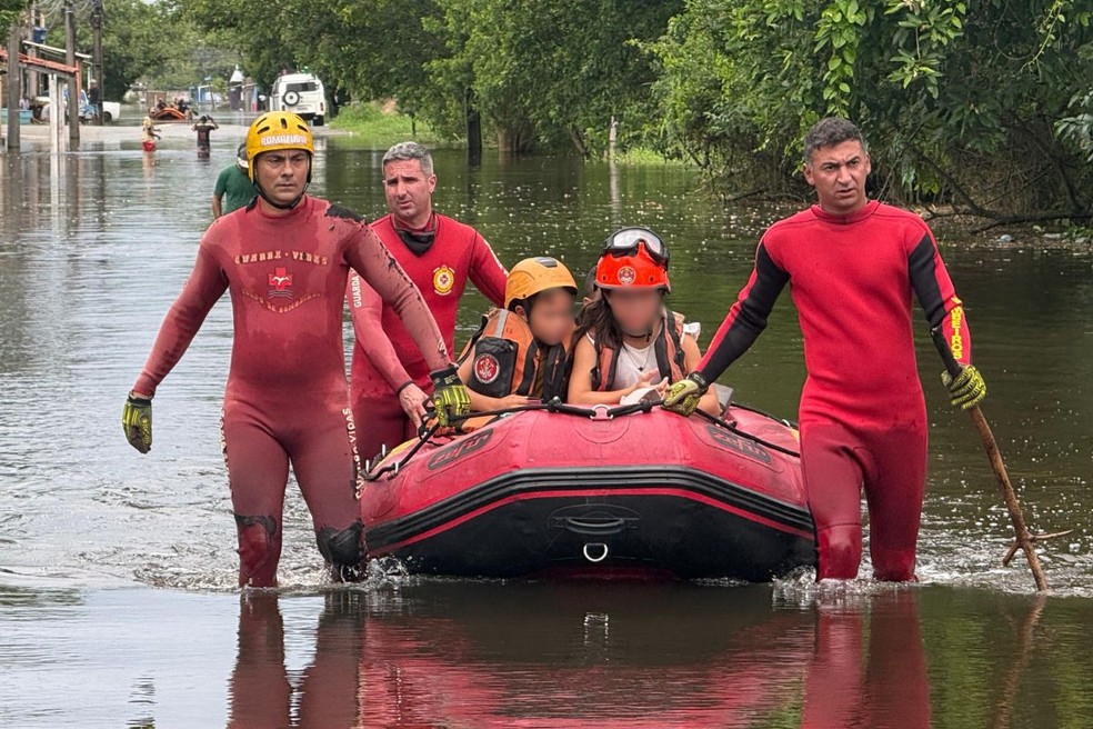 Crianças sendo resgatadas durante as chuvas em Peruíbe, SP — Foto: Yasmin Braga/TV Tribuna