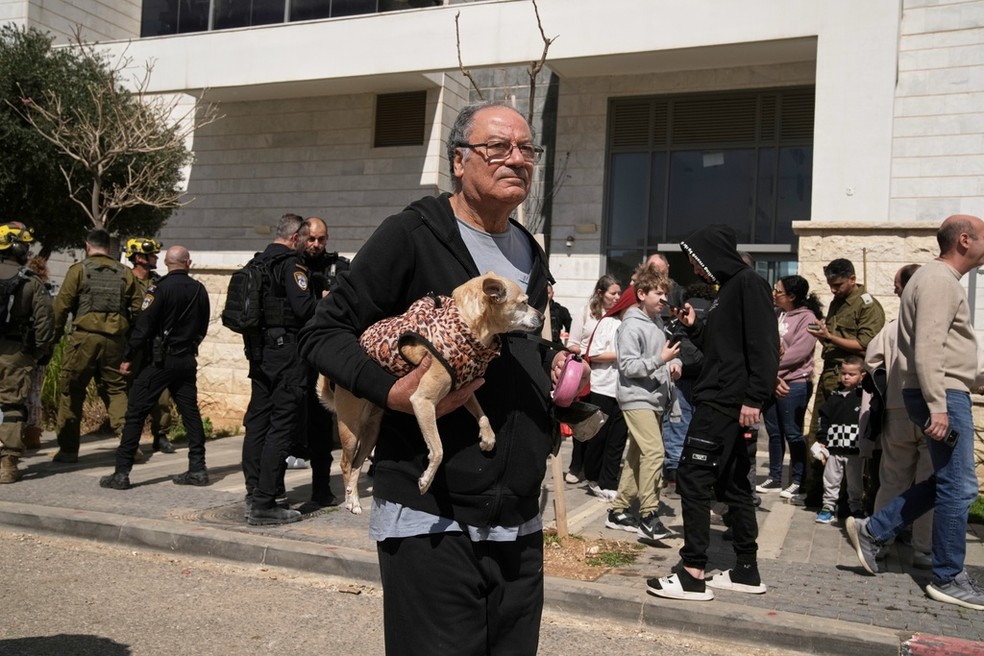 Moradores são evacuados de um prédio atingido por um projétil em Tirat Hacarmel, perto de Haifa, no norte de Israel, sábado, 28 de fevereiro de 2026. — Foto: AP Photo/Leo Correa