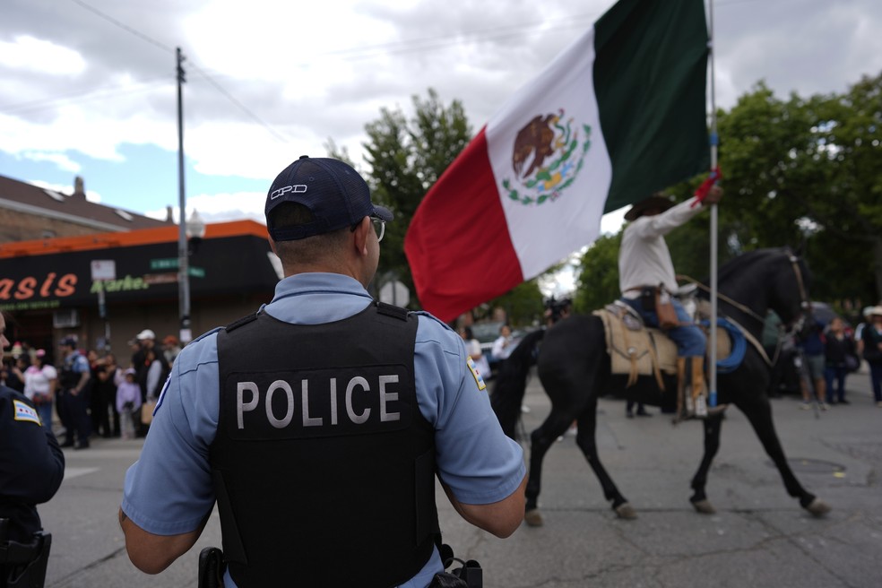 Policiais observam durante o desfile do Dia da Independência Mexicana de Pilsen, no sábado (6), em Chicago — Foto: AP/Carolyn Kaster