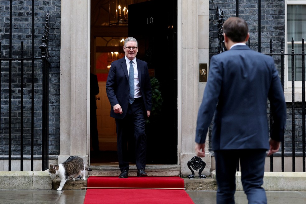 Gato Larry aparece durante recepção do premiê do Reino Unido, Keir Starmer, ao presidente da França, Emmanuel Macron, na residência oficial do governo britânico em 8 de dezembro de 2025. — Foto: REUTERS/Toby Melville/Pool