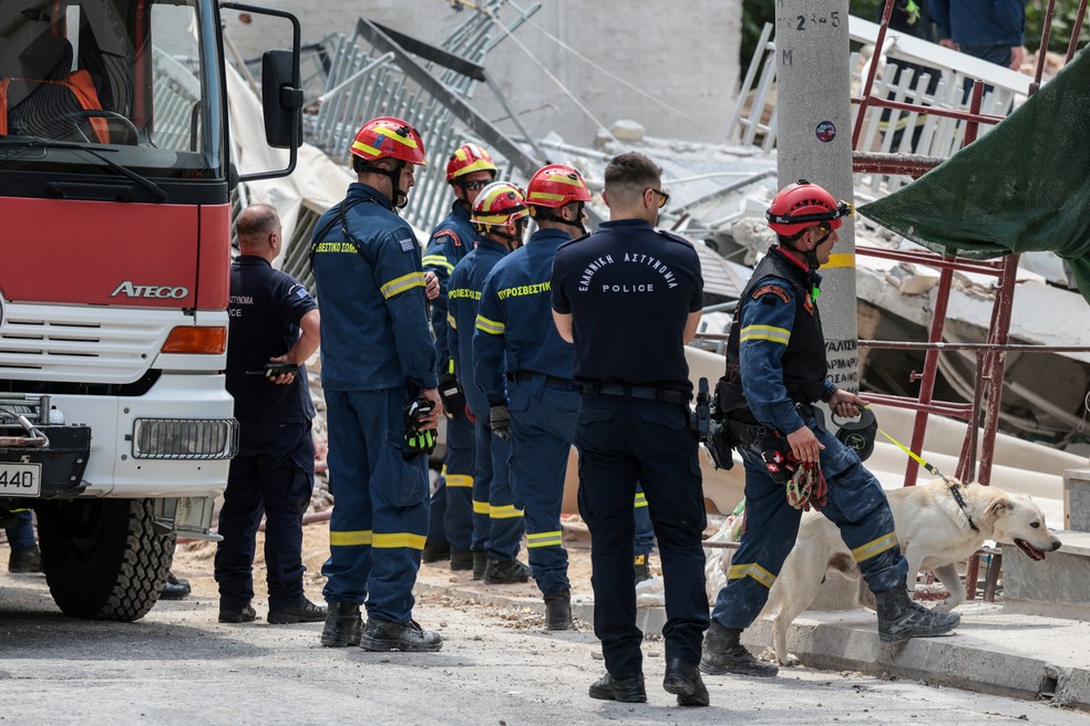 Equipes de emergência trabalham no local do desabamento de um prédio no bairro de Petralona, ​​em Atenas. — Foto: REUTERS/Louisa Gouliamaki