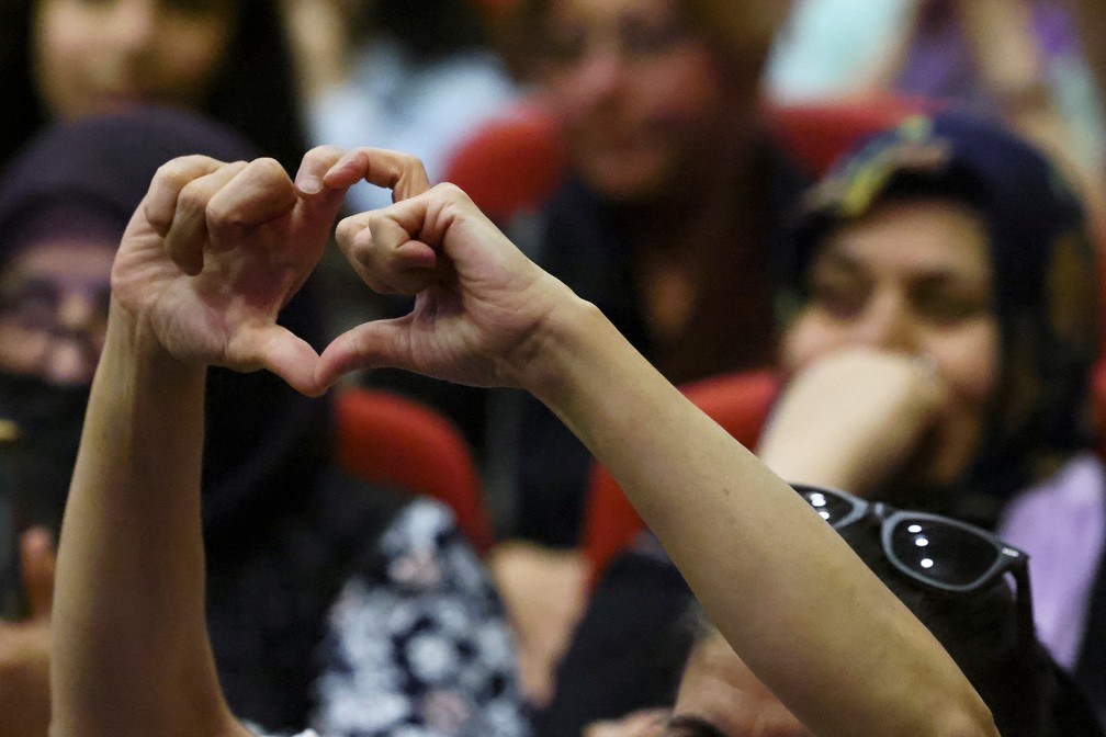 Apoiadora do candidato turco Kemal Kilicdaroglu faz famoso símbolo de coração com as mãos — Foto: Yves Herman/REUTERS