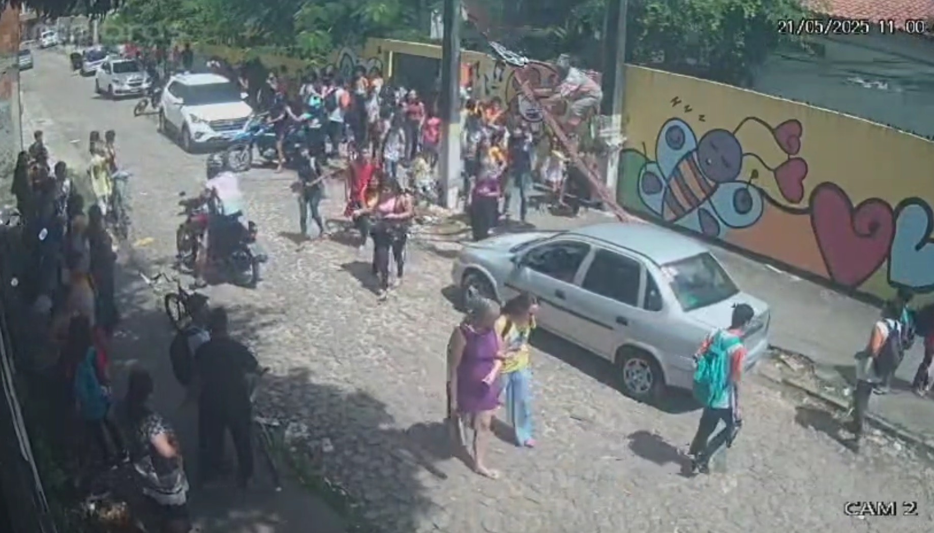 Vídeo: homem apoia escada em fios de poste na frente de escola e cai durante saída de alunos