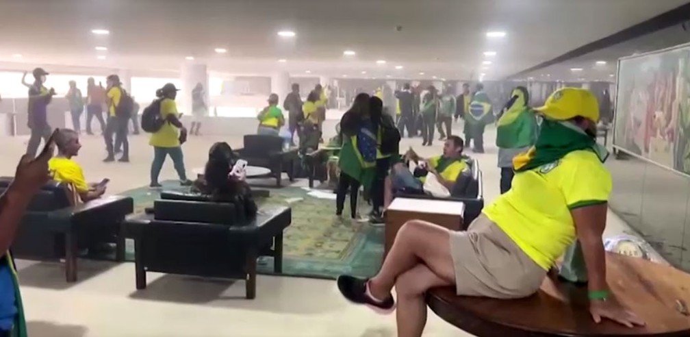 Golpistas sentados em mobiliário após invasões a prédios dos três poderes em Brasília neste domingo (8) — Foto: Reprodução / Reuters