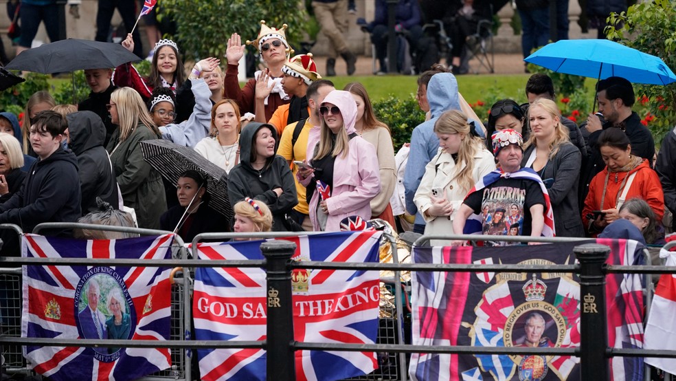 Fãs antes do início do desfile de aniversário do Rei Charles III, evento conhecido como Trooping The Colour — Foto: Alberto Pezzali / AP Photo
