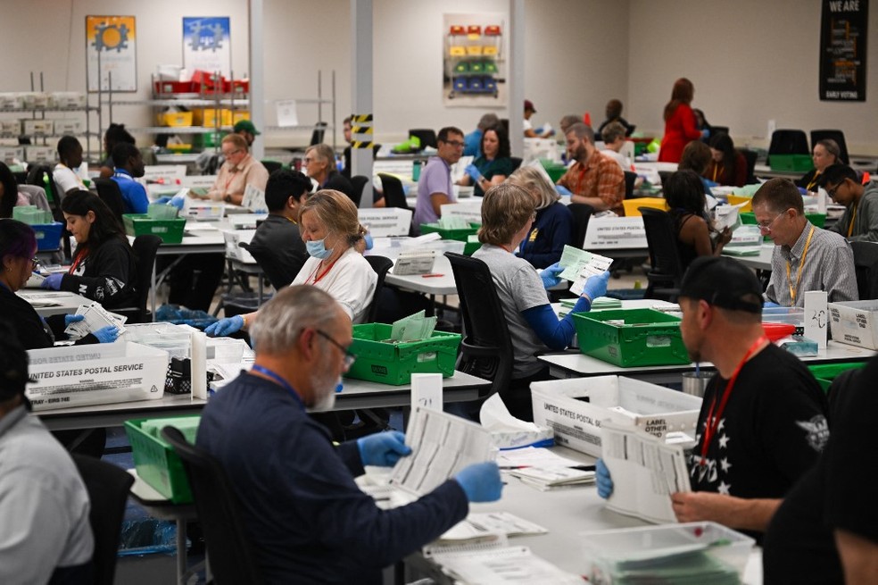 Trabalhadores eleitorais participam do processo de contagem de votos para a eleição presidencial dos EUA de 2024 no dia da eleição — Foto: Patrick T. Fallon / AFP