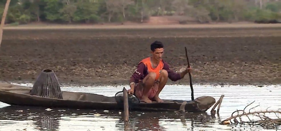 Pescadores tentam pescar o que sobrou dos peixes mortos — Foto: Reprodução/TV Globo