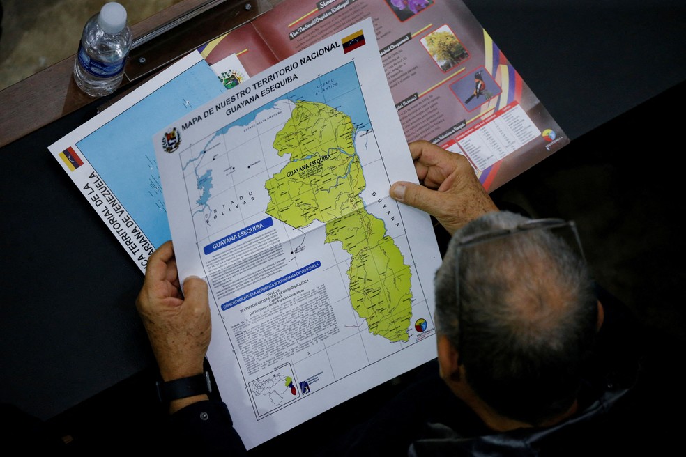 Membro da Assembleia Nacional da Venezuela segura um mapa que mostra a disputada região de Essequibo como parte da Venezuela. — Foto: Leonardo Fernandez Viloria/Reuters