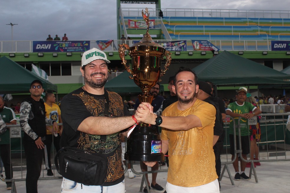 Presidentes da Império do Povo e Piratas da Batucada levantam o troféu de campeões — Foto: Isadora Pereira/g1