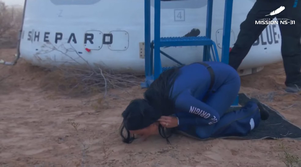 Katy Perry beija o chão após sair da nave. — Foto: Reprodução/Blue Origin