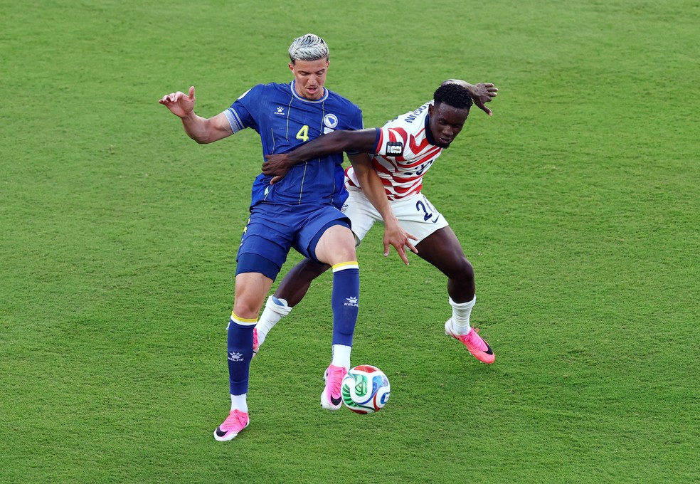 Folarin Balogun, dos EUA, comete falta em Tarik Muharemovic, da Bósnia e Herzegovina, antes de receber o cartão vermelho. — Foto: Pedro Nunes / Reuters