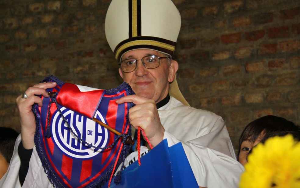 O então cardeal Jorge Mario Bergoglio posa para foto segurando uma flâmula do seu time — Foto: Club Atlético San Lorenzo de Almagro/AP