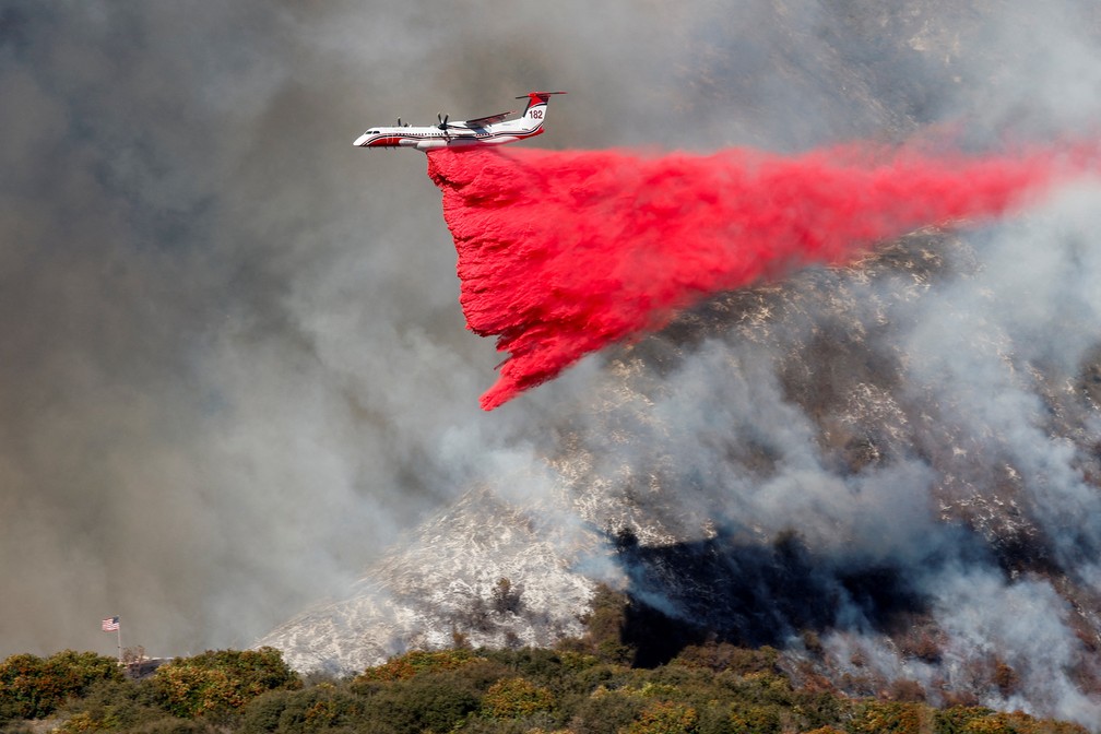 Avião despeja retardante de fogo sobre área em chamas em Mandeville Canyon, em Los Angeles — Foto: Shannon Stapleton/Reuters