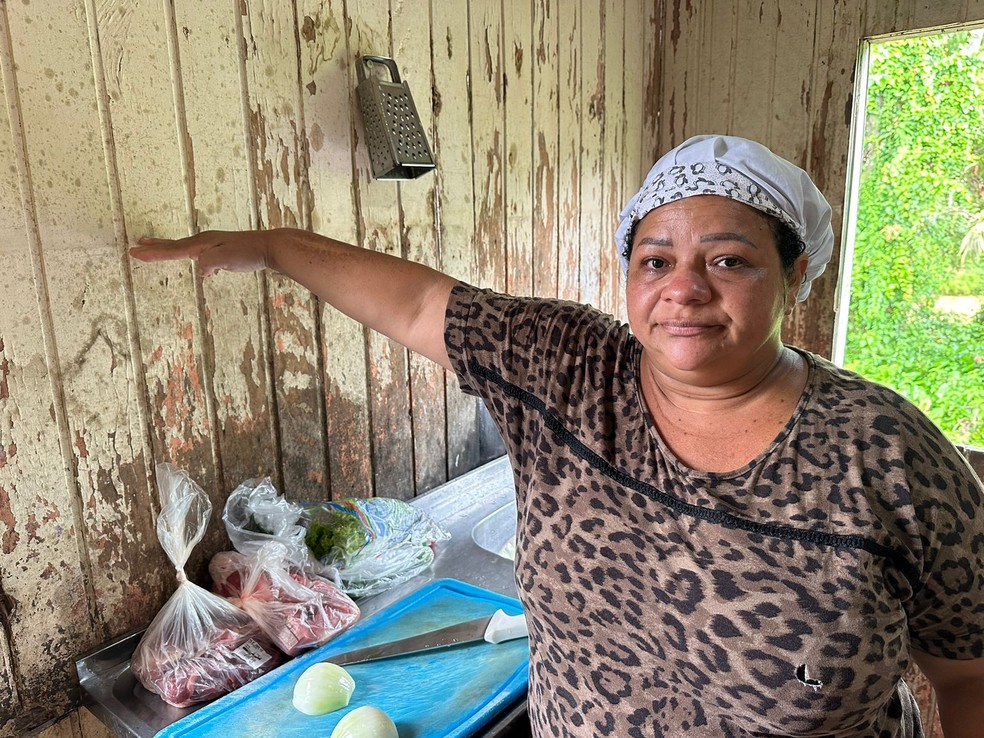 Moradora das margens do Igarapé São Francisco mostra altura atingida por transbordamento em 2023 — Foto: Andryo Amaral/Rede Amazônica Acre
