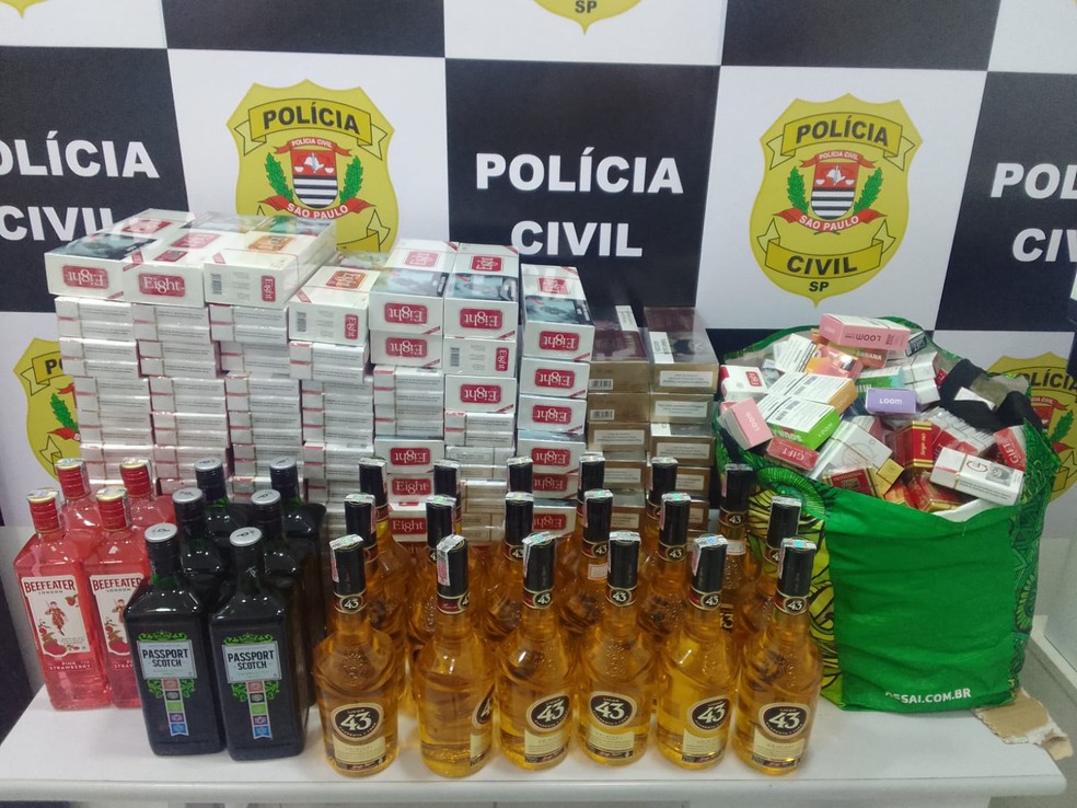Garrafas de whisky, gin e licor falsificadas ou adulteradas foram apreendidas em adega, no bairro Trevo, em Praia Grande — Foto: Polícia Civil/Divulgação