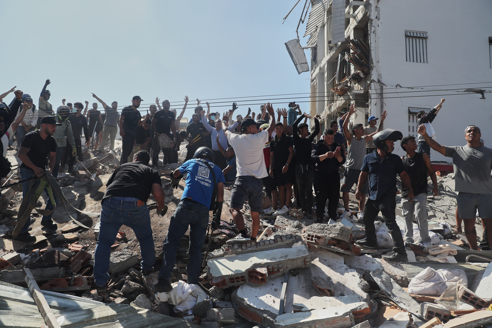 Moradores e equipes de resgate vasculham os escombros de um pr�dio que desabou ap�s um terremoto atingir Cali, Col�mbia, na segunda-feira, 10 de agosto de 2026 � Foto: AP/Santiago Saldarriaga