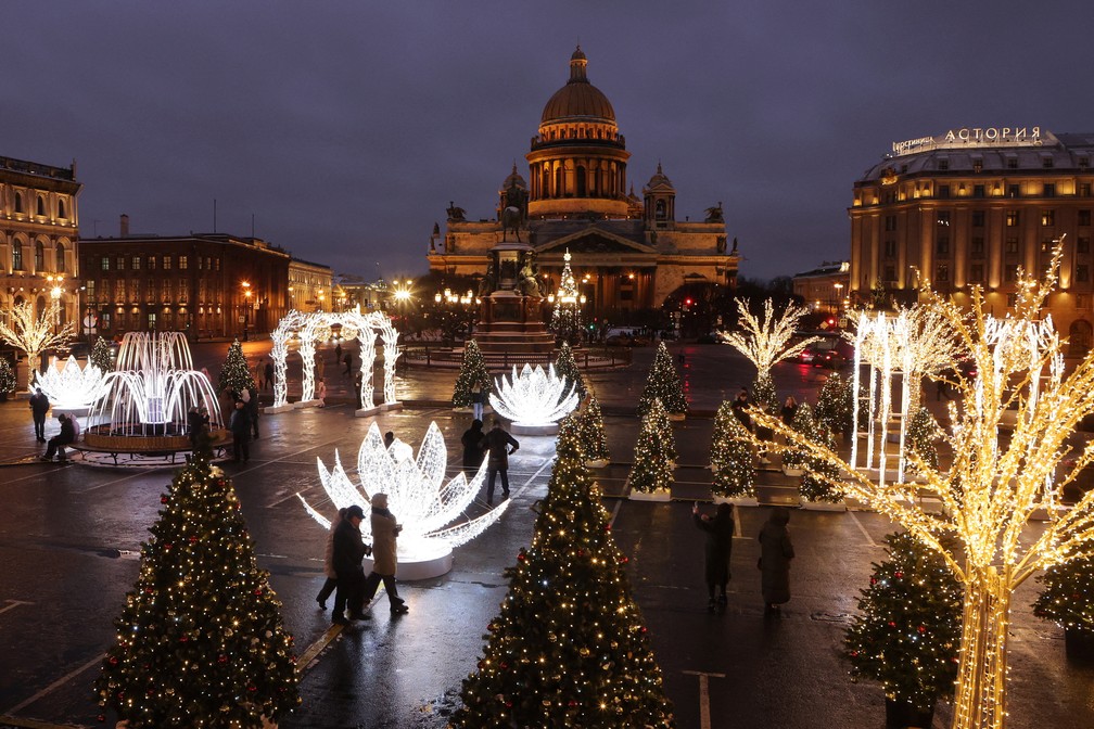 Pessoas caminham em meio a decorações de Ano Novo instaladas perto da Catedral de Santo Isaac, no centro de São Petersburgo, Rússia, em 24 de dezembro de 2025. REUTERS/Anton Vaganov — Foto: REUTERS/Anton Vaganov