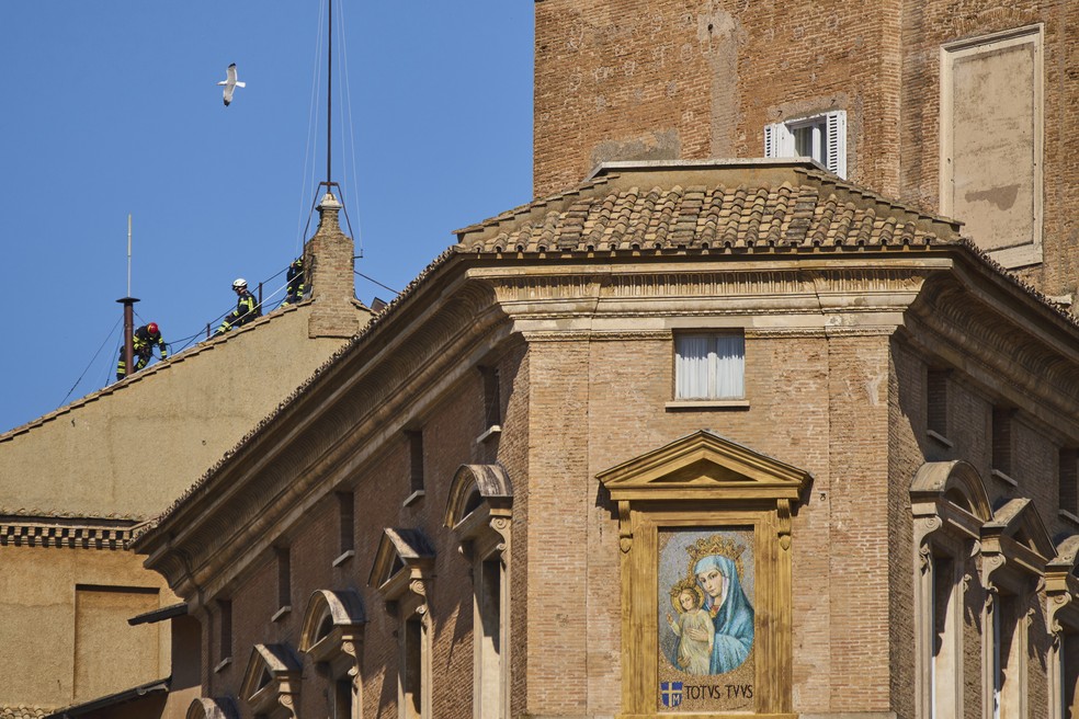 Bombeiros trabalham na instalação da chaminé na Capela Sistina, no Vaticano — Foto: Bernat Armangue/AP Photo