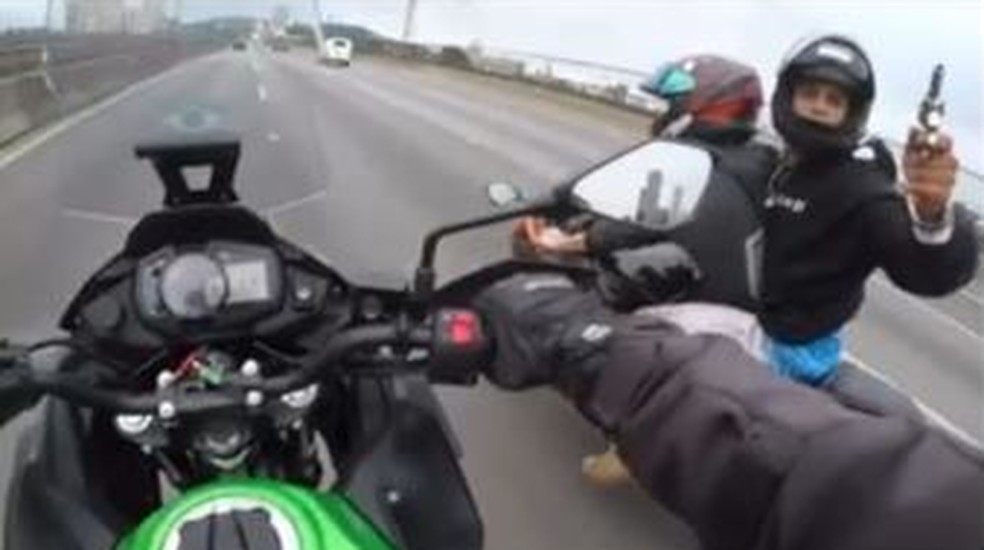 Assaltante armado aponta arma para motociclista e rouba sua moto durante perseguição na Rodovia Castello Branco, em Barueri, Grande São Paulo — Foto: Reprodução/Redes sociais