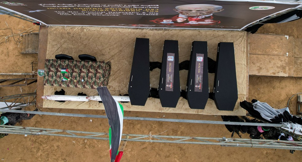 Caixões pretos contendo restos mortais de quatro reféns israelenses, incluindo três integrantes da família Bibas, entregues pelo Hamas a Israel em 20 de fevereiro de 2025. — Foto: REUTERS/Stringer