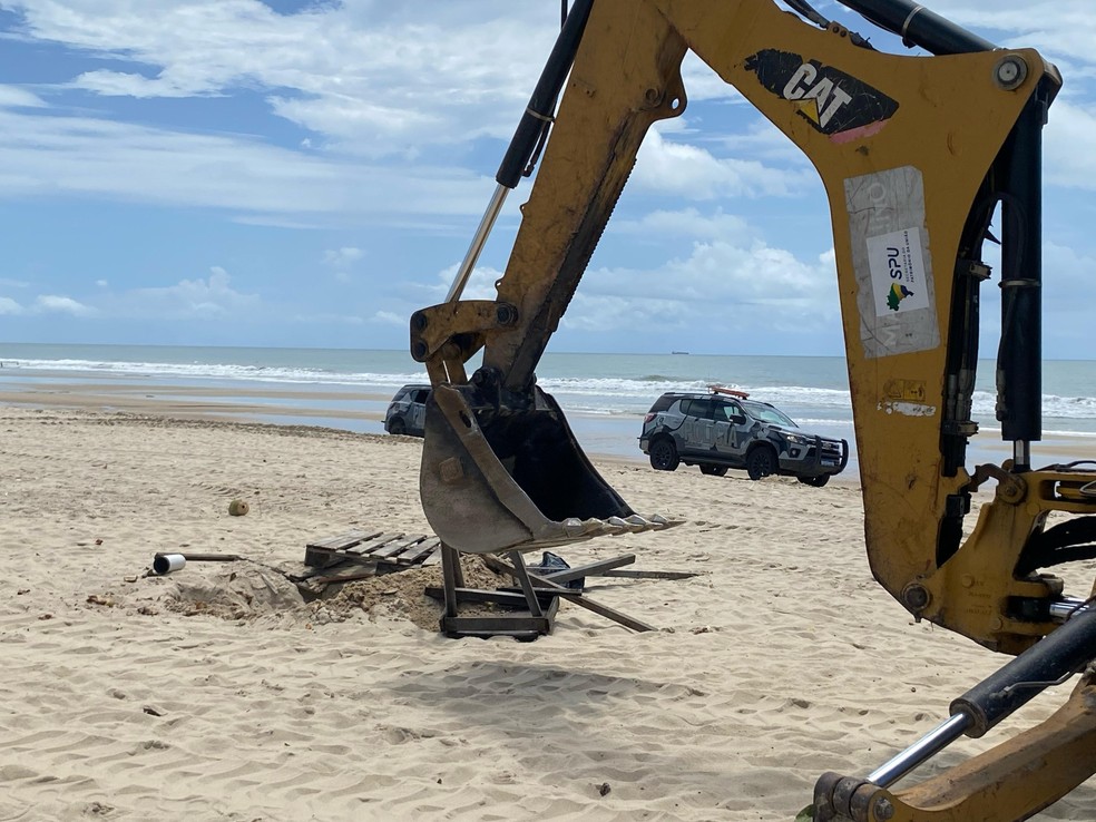 Retroescavadeira em operação para retirada de barracas na faixa de areia da Praia do Futuro, em Fortaleza — Foto: Nathally Kimberly/SVM