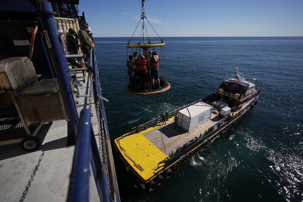 Integrantes da Expedição 501 descem da plataforma Liftboat Robert para o navio de apoio Gaspee em uma cesta de transferência Billy Pugh, no Atlântico Norte, em 19 de julho de 2025. — Foto: Carolyn Kaster/AP