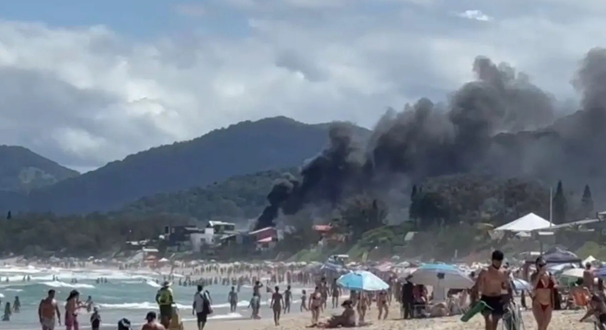 Coluna de fumaça impressiona banhistas que lotam praia turística de Florianópolis; VÍDEO