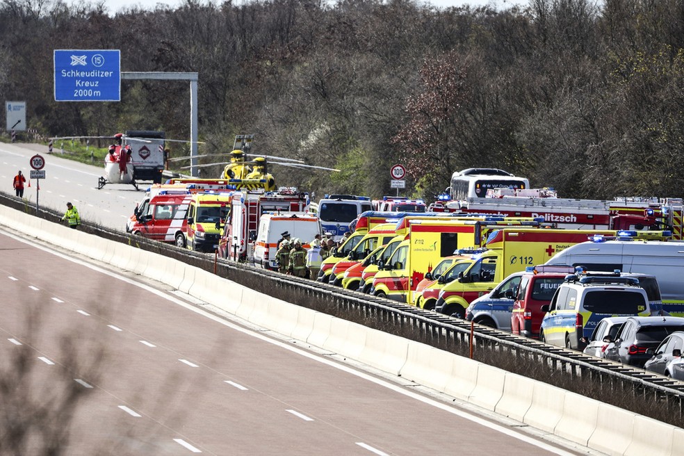 Ambulâncias e helicópteros param em pista de autoestrada da Alemanha para socorrer vítimas após ônibus capotar perto de Leipzig, em 27 de março de 2024. — Foto: Jan Woitas/dpa via AP