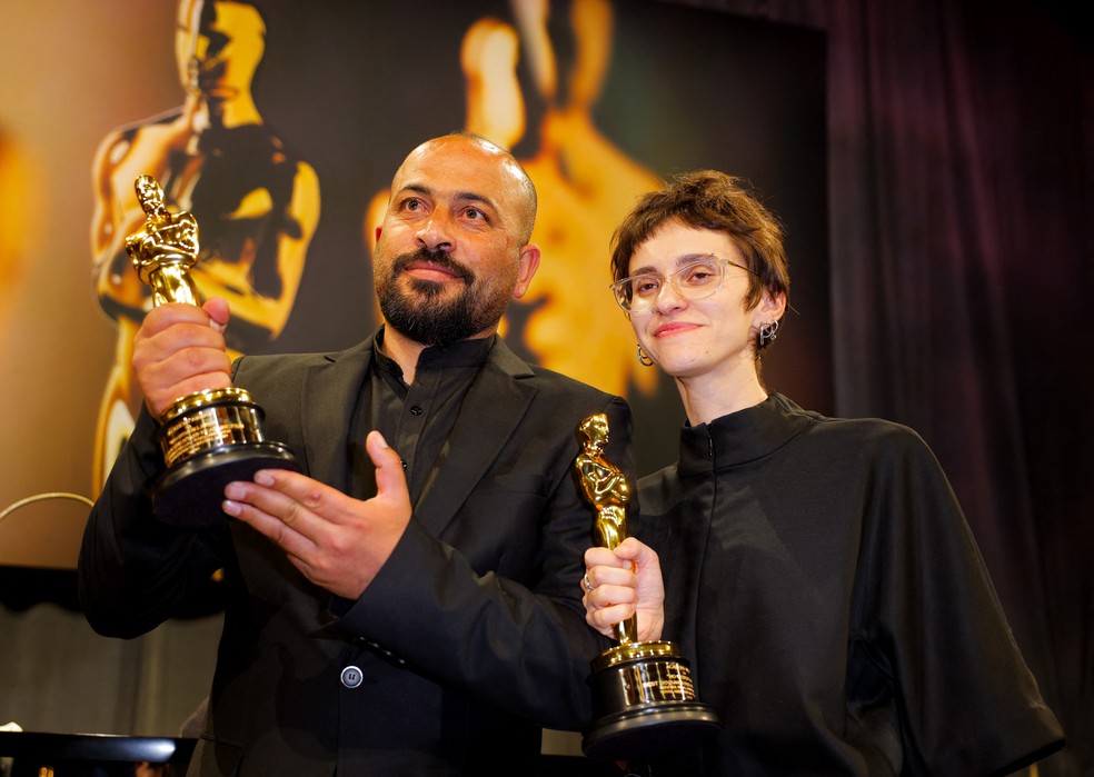 Hamdan Ballal (à esquerda) ergue estatueta do Oscar em Los Angeles, em 2 de março de 2025 — Foto: Mike Blake/Reuters
