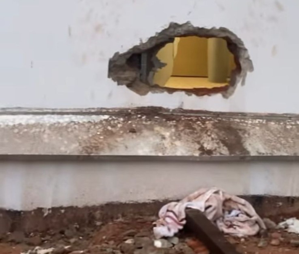 Buraco foi feito em parede de casa que fazia divisa com o banco � Foto: Divulga��o