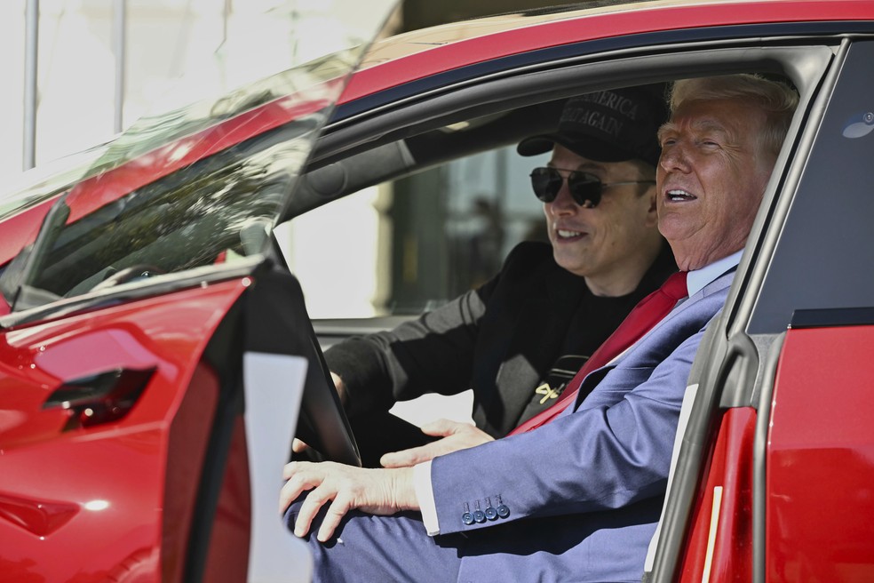 Elon Musk e Donald Trump com Tesla Model S vermelho