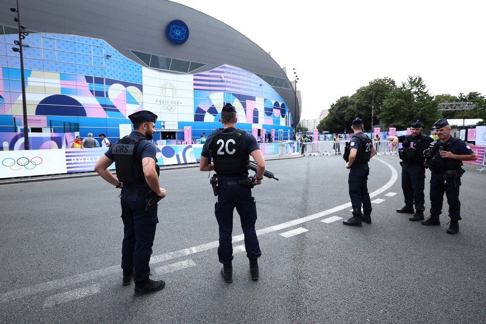 Policiais franceses patrulham lado externo do Estádio Parque dos Príncipes antes da partida de futebol masculino entre Uzbequistão e Espanha, durante os Jogos Olímpicos de Paris 2024, em Paris, no dia 24 de julho — Foto: Franck Fife/AFP
