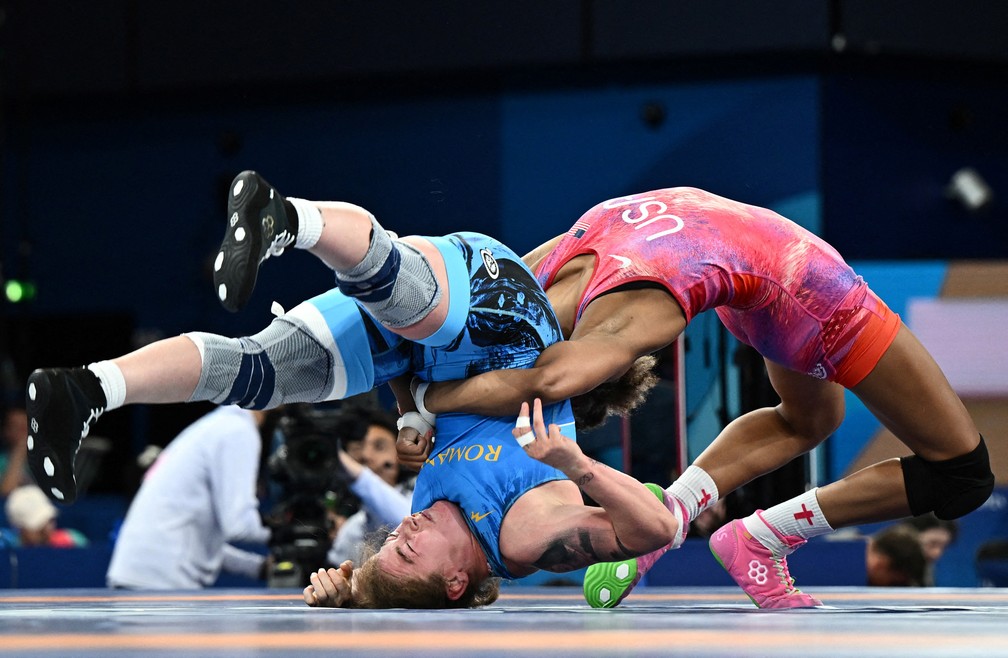 O americano Kennedy Alexis Blades aplica um golpe em Catalina Axente, da Romênia, durane final feminina de wrestling — Foto: Arlette Bashizi/Reuters