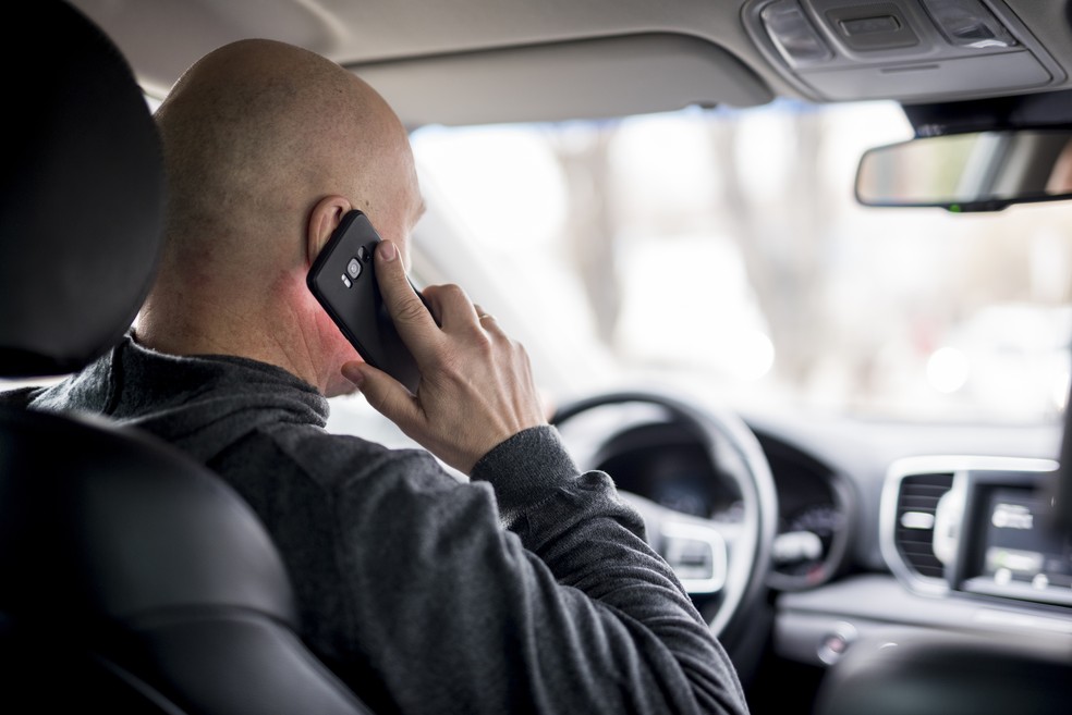 Homem dirigindo enquanto falar ao celular — Foto: Reprodução/Freepik