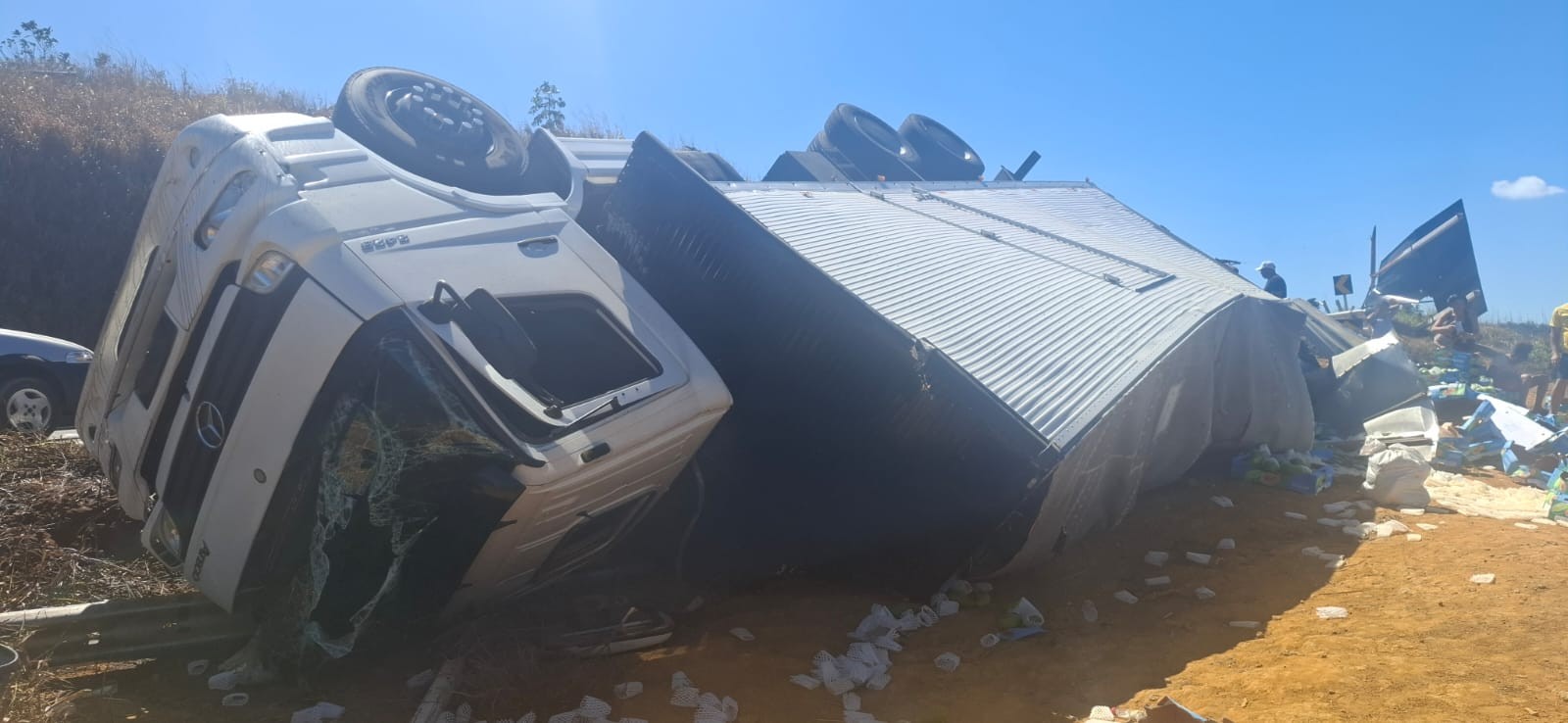 Caminhão carregado com mamão tomba em curva na LMG-760 e motorista fica ferido em Dionísio