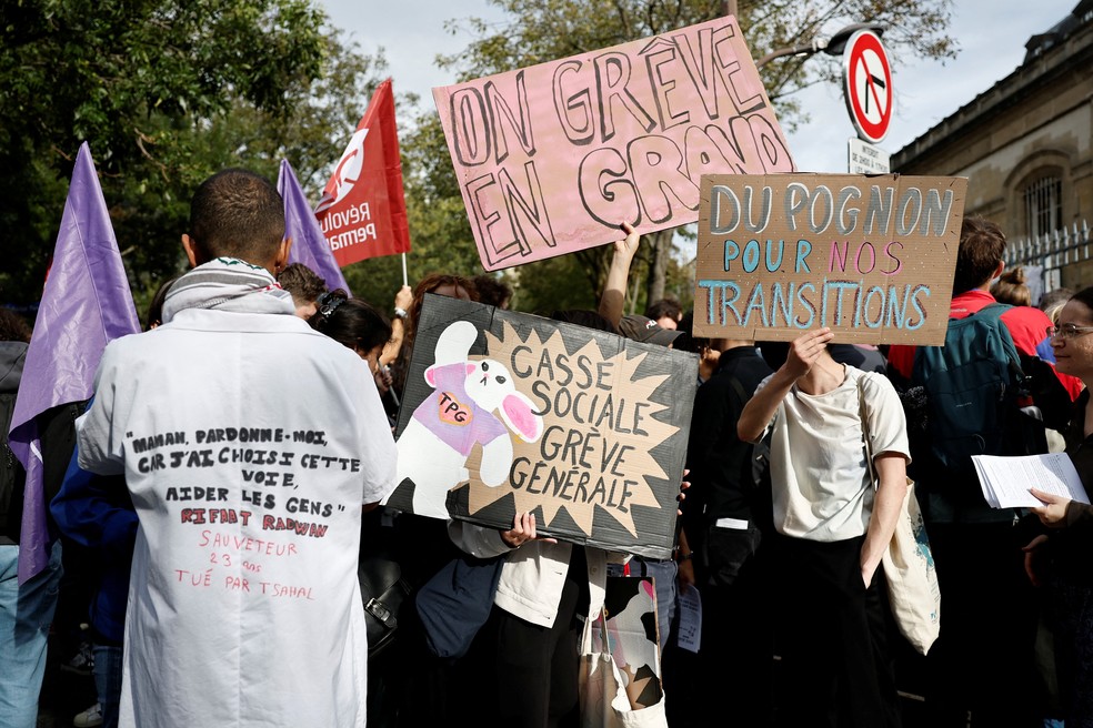 Manifestantes seguram cartazes enquanto se reúnem em frente ao hospital Tenon durante um dia de protestos em Paris, como parte de um movimento de protesto popular chamado 'Bloquons Tout' ('Vamos Bloquear Tudo'), que pede interrupções nacionais durante todo o dia — Foto: Benoit Tessier/Reuters