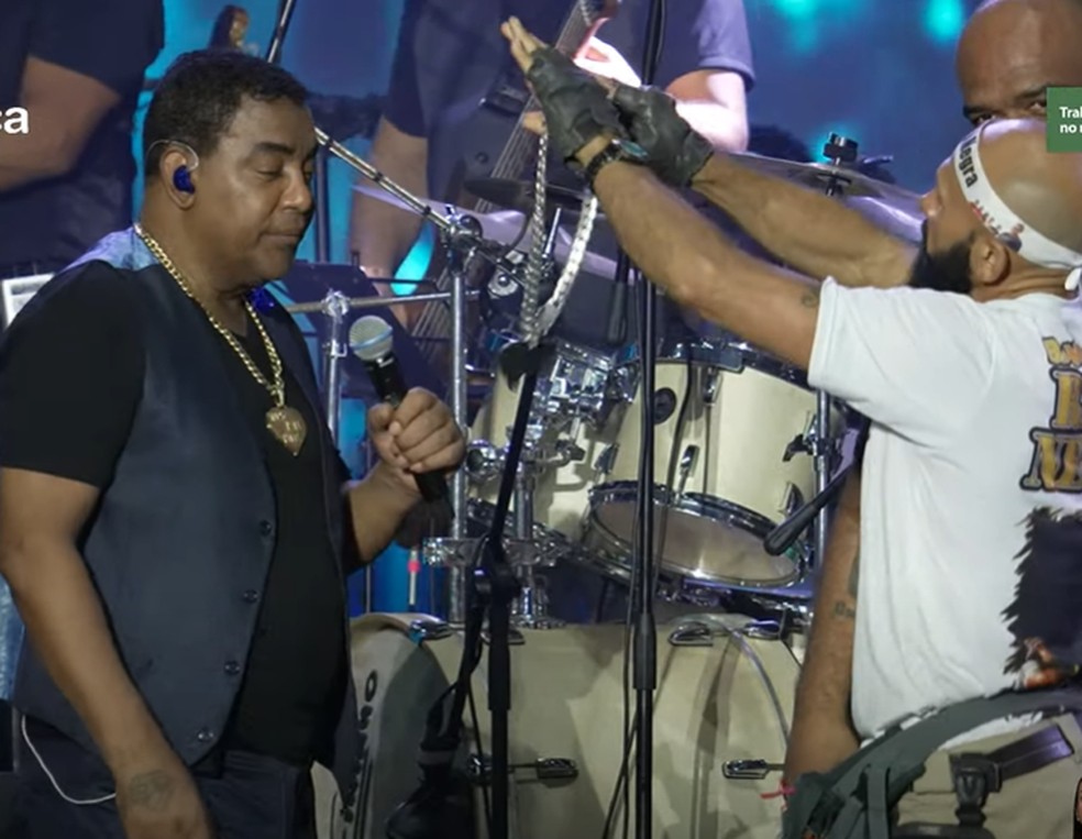 Fã invade palco e entrega colar para Luiz Carlos, vocalista de Raça Negra, em Campina Grande — Foto: Reprodução/Sua Música