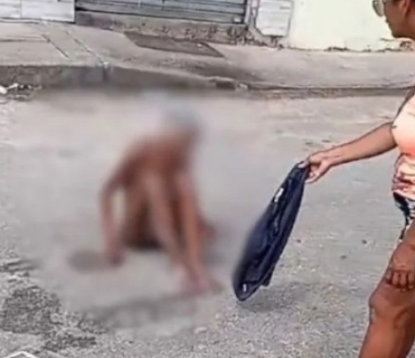 Moradores oferecem roupas para a idosa se cobrir, após a encontrarem nua no meio da rua em Camaçari — Foto: Redes sociais