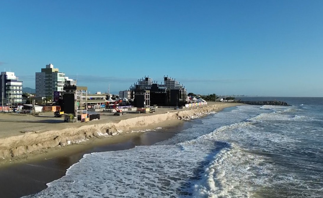 Mar avança de novo e forma paredão de areia em praia de Matinhos, ao lado da estrutura onde Governo do Paraná promove shows de verão
