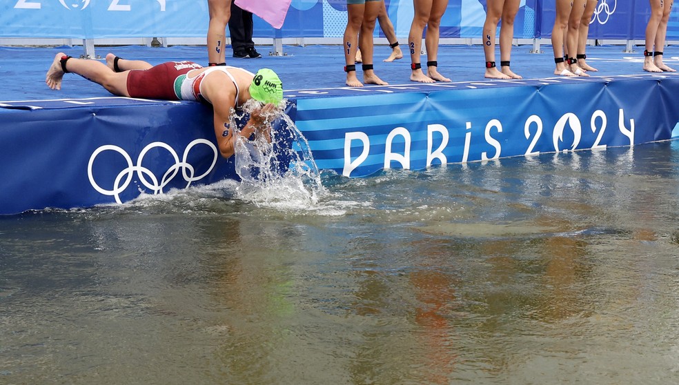 Atleta se molha com água do Rio Sena pouco antes da prova do triatlo nos Jogos de Paris 2024 — Foto: Lisa Leutner/Reuters