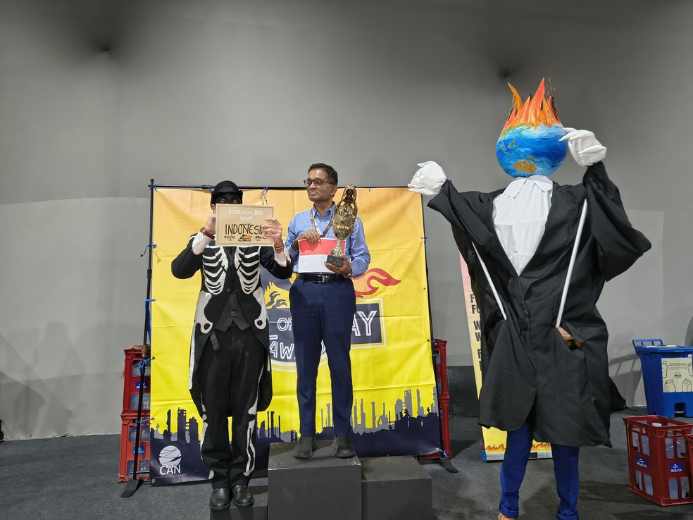 Ativistas entregam o “Fóssil do Dia” à Indonésia durante cerimônia satírica na COP30, em Belém. — Foto: Climate Action Network