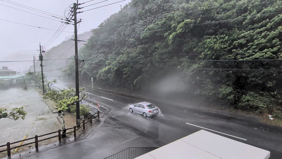 Um carro atravessa fortes ventos e chuva enquanto o tufão Dolphin se aproxima, em Nazeasahicho, Amami, Kagoshima, Japão — Foto: REUTERS