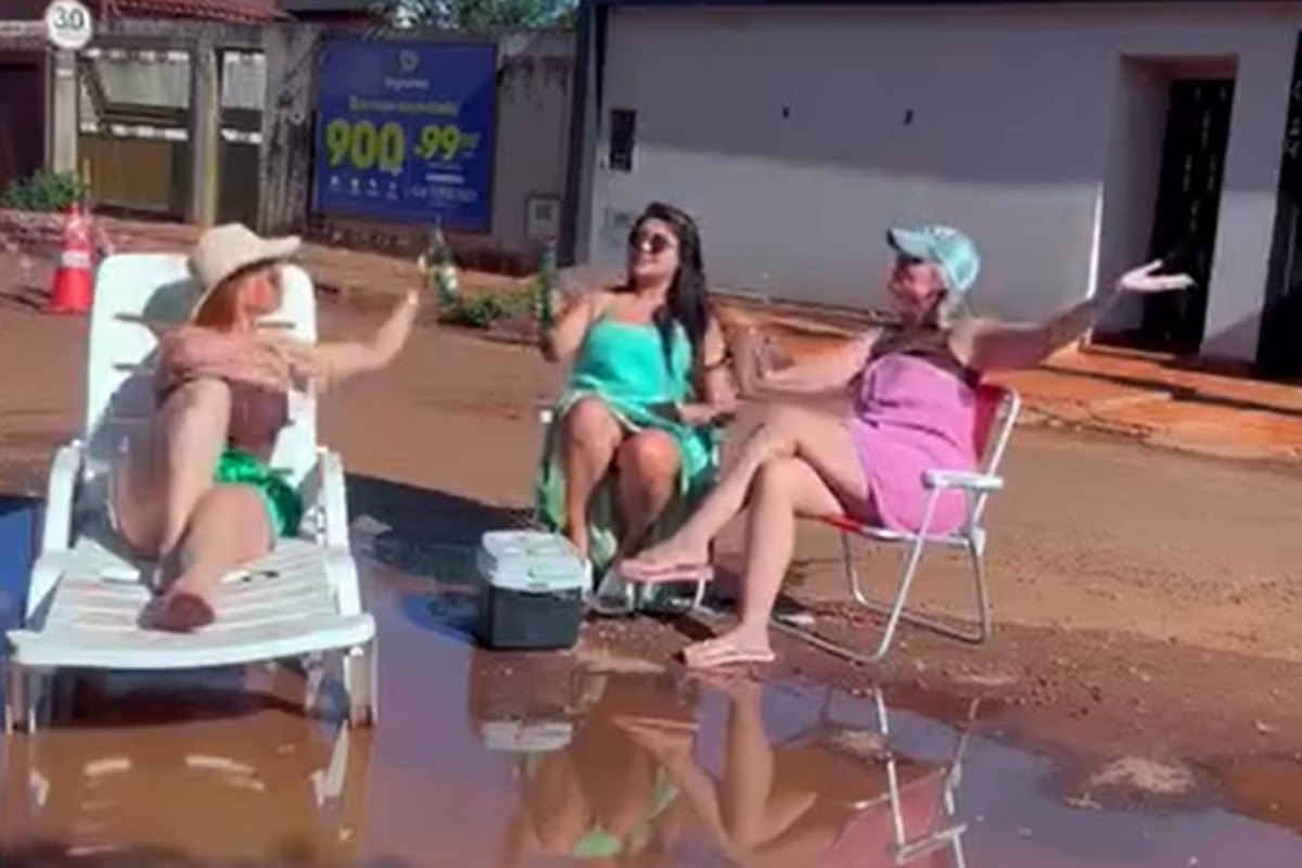 Amigas simulam 'praia particular' em protesto contra buraqueira em rua de Campo Grande; veja VÍDEO