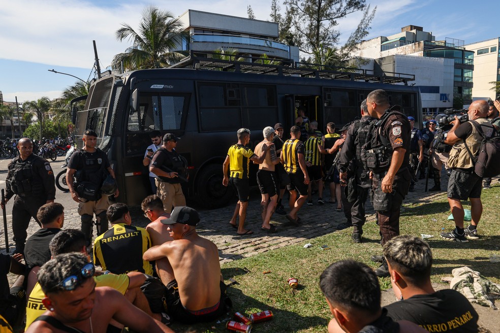 Torcedores do Peñarol são detidos após briga no Recreio dos Bandeirantes, nesta quarta-feira (23) — Foto: Renan Areias/Agência O Dia/Estadão Conteúdo