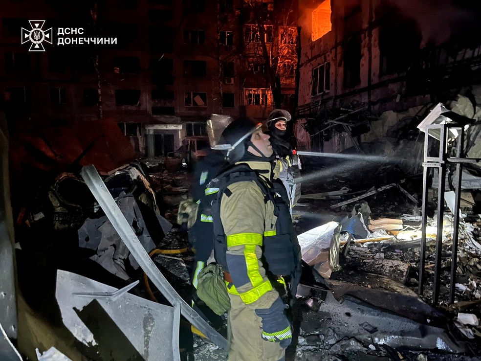 Bombeiros trabalham no local de uma área residencial atingida por um ataque militar russo, em meio ao ataque da Rússia à Ucrânia, na cidade de Dobropillia, região de Donetsk — Foto: Imprensa do Serviço de Emergência Estadual da Ucrânia na região de Donetsk/Divulgação via Reuters